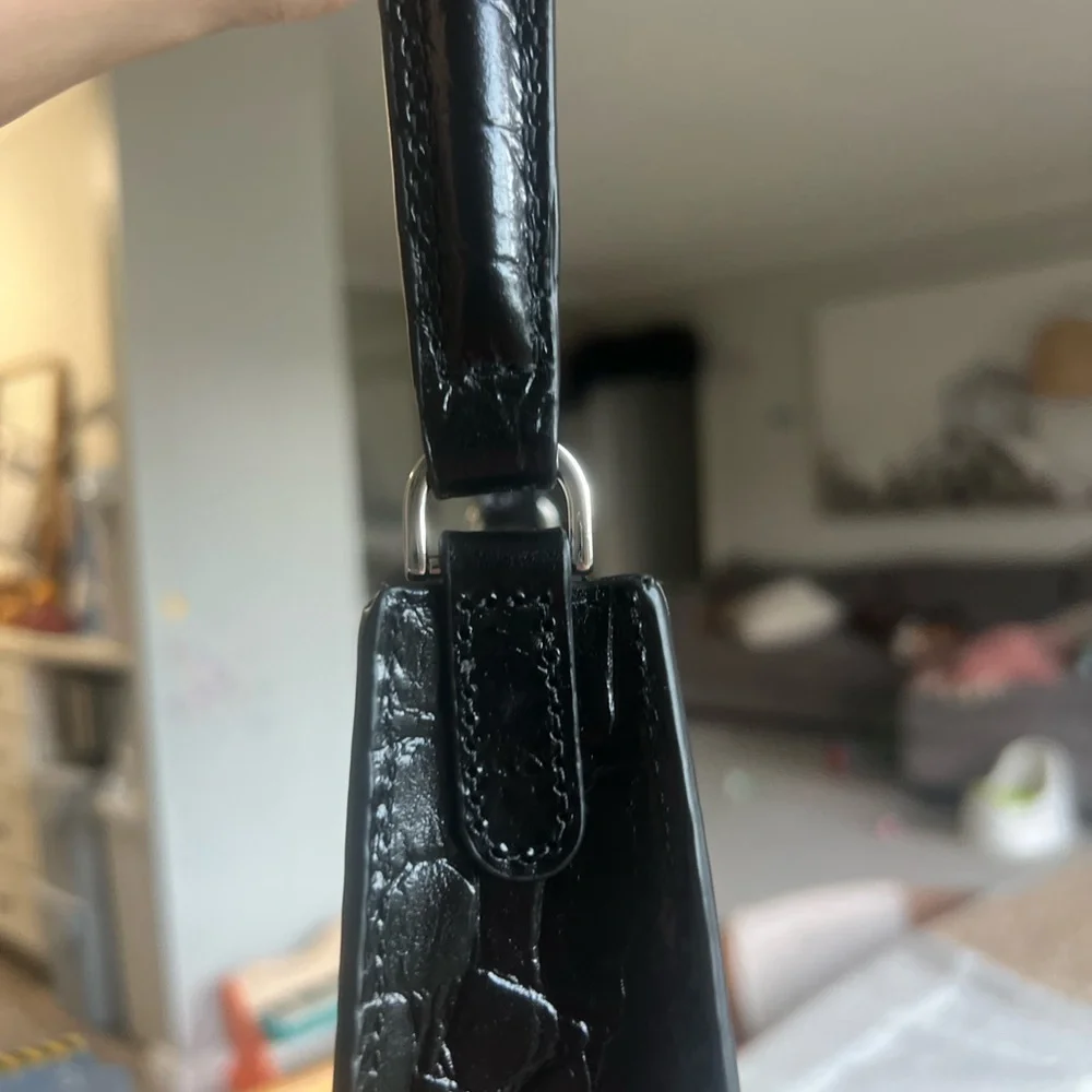 The STAUD Rey Bag in black is a triangular leather bag featuring a top handle - Picture 5 of 5